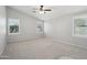 Spacious bedroom with neutral walls, carpet flooring, two windows, and a ceiling fan at 20626 N 55Th Ave, Glendale, AZ 85308