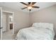 Neutral bedroom with a ceiling fan and view of the bathroom connected to the bedroom at 20626 N 55Th Ave, Glendale, AZ 85308
