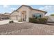 Tan single-story home featuring a two-car garage, desert landscaping, and a welcoming front entrance at 20626 N 55Th Ave, Glendale, AZ 85308