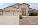 Beige single-story home featuring a two-car garage, desert landscaping, and a cozy front entryway at 20626 N 55Th Ave, Glendale, AZ 85308