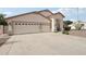 Beige home showcasing a large driveway, two-car garage, desert landscaping, and inviting entrance at 20626 N 55Th Ave, Glendale, AZ 85308