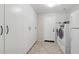 Laundry room with tiled flooring, washing machine, dryer, and storage cabinets at 20626 N 55Th Ave, Glendale, AZ 85308