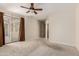 This is a bright bedroom featuring carpet, a ceiling fan, and a sliding glass door to the backyard at 27250 N 86Th Ave, Peoria, AZ 85383