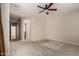 Spacious bedroom with carpet flooring, ceiling fan, and a view into the ensuite bathroom at 27250 N 86Th Ave, Peoria, AZ 85383