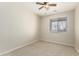 This bedroom features neutral walls, carpeted floors, a ceiling fan, and a window for natural light at 27250 N 86Th Ave, Peoria, AZ 85383