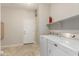 Functional laundry room featuring tile floors, and a washer and dryer set, adjacent to a convenient exterior access door at 27250 N 86Th Ave, Peoria, AZ 85383