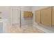 The laundry room has travertine tile, light wood cabinets, and a washer and dryer at 27250 N 86Th Ave, Peoria, AZ 85383