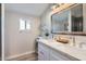 Bright bathroom featuring a double sink vanity with a large framed mirror at 4525 E Rhonda Dr, Phoenix, AZ 85018