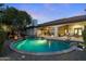 An in-ground pool with rock features and mature landscaping is ideal for outdoor entertaining at 4914 N Valley Gln, Litchfield Park, AZ 85340