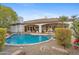 Backyard features an in-ground pool with lush landscaping and a covered patio perfect for outdoor entertaining at 4914 N Valley Gln, Litchfield Park, AZ 85340