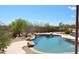 Sparkling pool with stone accents, complemented by natural desert landscaping and a clear blue sky at 509 E Seco Pl, Phoenix, AZ 85086