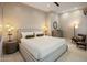 A spacious bedroom with a ceiling fan, lamps, and neutral colored walls at 6166 N Scottsdale Rd # A3001, Paradise Valley, AZ 85253