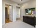 A carpeted bedroom with multiple doors, a TV, and a storage console at 6166 N Scottsdale Rd # A3001, Paradise Valley, AZ 85253