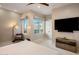 A spacious bedroom with a large window, a TV, and a ceiling fan at 6166 N Scottsdale Rd # A3001, Paradise Valley, AZ 85253