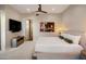 Spacious bedroom with a ceiling fan, tv, and an ensuite bathroom at 6166 N Scottsdale Rd # A3001, Paradise Valley, AZ 85253