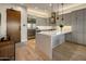 Sleek kitchen with stainless steel appliances and a large quartz island, pendant lights, and hardwood flooring at 6166 N Scottsdale Rd # A3001, Paradise Valley, AZ 85253