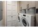 Well-organized laundry room featuring modern appliances, custom cabinets and storage baskets at 6166 N Scottsdale Rd # A3001, Paradise Valley, AZ 85253