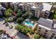 Aerial view of a luxurious community pool and jacuzzi surrounded by lush landscaping and umbrella-covered lounge chairs at 6166 N Scottsdale Rd # A3001, Paradise Valley, AZ 85253