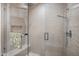 A tiled shower with a rainfall shower head, seating, and a glass door at 6166 N Scottsdale Rd # A3001, Paradise Valley, AZ 85253