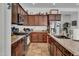 A well-appointed kitchen features dark wood cabinets, stainless steel appliances, and granite countertops at 727 E Monte Way, Phoenix, AZ 85042
