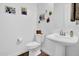 Clean powder room with pedestal sink, toilet, and art pieces at 727 E Monte Way, Phoenix, AZ 85042