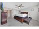 A well-lit main bedroom includes carpet, a large bed, a ceiling fan, and a view to the hallway at 8347 W Surrey Ave, Peoria, AZ 85381