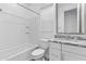 A full white bathroom with granite countertops, tiled shower surround, and a white cabinet at 9624 E Twinkle Cir, Mesa, AZ 85212