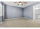 Spacious bedroom with a ceiling fan and a door leading to the bathroom at 9624 E Twinkle Cir, Mesa, AZ 85212