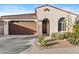 Charming single-story home featuring a brown garage door and desert landscaping at 9624 E Twinkle Cir, Mesa, AZ 85212