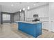 Open kitchen with stainless appliances, white cabinets, blue island, and light-filled adjacent living spaces at 9624 E Twinkle Cir, Mesa, AZ 85212