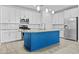 Well-appointed kitchen features white cabinetry, stainless steel appliances and a contrasting blue island at 9624 E Twinkle Cir, Mesa, AZ 85212