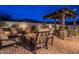 Inviting backyard patio with a fire pit, comfortable seating, and a pergola with string lights for outdoor relaxation at 10254 W Bent Tree Dr, Peoria, AZ 85383