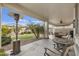 Relaxing covered patio featuring comfortable seating, ceiling fan, and view of the landscaped backyard at 10312 E Tupelo Ave, Mesa, AZ 85212