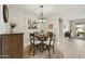 Cozy dining area with a round table, four chairs, a stylish light fixture, and natural light at 10312 E Tupelo Ave, Mesa, AZ 85212