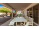 Stylish covered patio showcasing an elegant dining table and inviting seating area with a fire pit at 10330 W Gulf Hills Dr, Sun City, AZ 85351