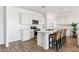 Stylish modern kitchen with white cabinetry, plank flooring, and a large island at 12398 E Bahia Ct, Florence, AZ 85132