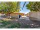 Exterior view showing a large backyard with a patio, lush trees, and ample room for recreation at 1426 E Indigo Cir, Mesa, AZ 85203