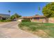 Lovely ranch-style home with lush landscaping and a long driveway at 1426 E Indigo Cir, Mesa, AZ 85203