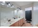 Bathroom with dual sinks, long counter, and black shower curtain at 15076 W Belmont Dr, Casa Grande, AZ 85194