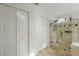 Bathroom featuring a walk-in shower with white cabinets and travertine tile at 15076 W Belmont Dr, Casa Grande, AZ 85194