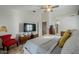This bedroom boasts a flatscreen tv, a red chair, and plenty of natural light at 15076 W Belmont Dr, Casa Grande, AZ 85194