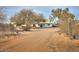 Wide exterior shot showing the property with desert landscaping and a long dirt driveway at 15076 W Belmont Dr, Casa Grande, AZ 85194