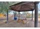 Covered picnic area with a wooden table, perfect for outdoor dining at 15076 W Belmont Dr, Casa Grande, AZ 85194