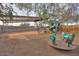 Backyard play area featuring a slide, play structures, and sandy ground cover at 15076 W Belmont Dr, Casa Grande, AZ 85194