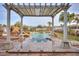 Inviting outdoor pool and spa area with a pergola and beautifully landscaped surroundings at 15076 W Belmont Dr, Casa Grande, AZ 85194