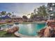 Beautiful backyard pool featuring rock waterfall and lush greenery at 15076 W Belmont Dr, Casa Grande, AZ 85194