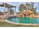 Luxurious pool area featuring a stunning rock waterfall and lush greenery at 15076 W Belmont Dr, Casa Grande, AZ 85194