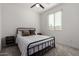 Well-lit bedroom with a black metal bed frame, simple decor, and neutral carpet at 17945 W Golden Ln, Waddell, AZ 85355