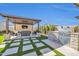 Outdoor kitchen with a built-in grill, tv, bar seating, manicured artificial grass with pavers and a covered patio at 1957 W Lonesome Trl, Phoenix, AZ 85085