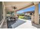 Spacious covered patio with dining area, ceiling fan, and outdoor kitchen with integrated grill and bar seating at 1957 W Lonesome Trl, Phoenix, AZ 85085